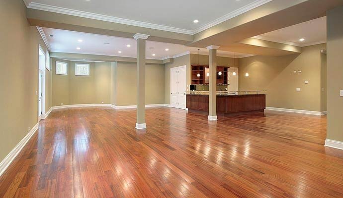 A large, finished basement featuring polished hardwood flooring