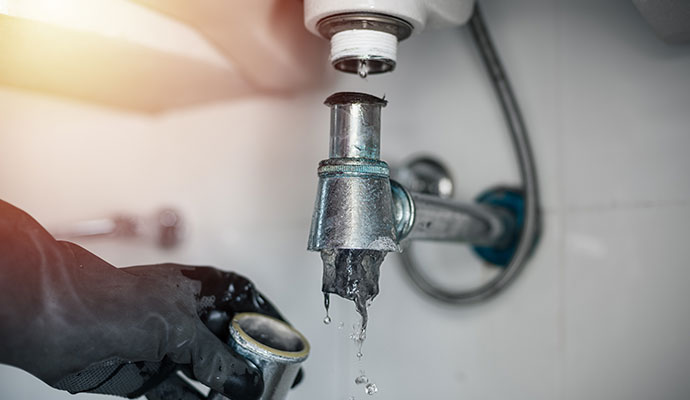 A person is repairing clogged drain