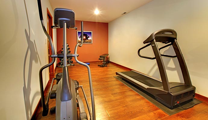 A fully equipped home gym set up in a basement