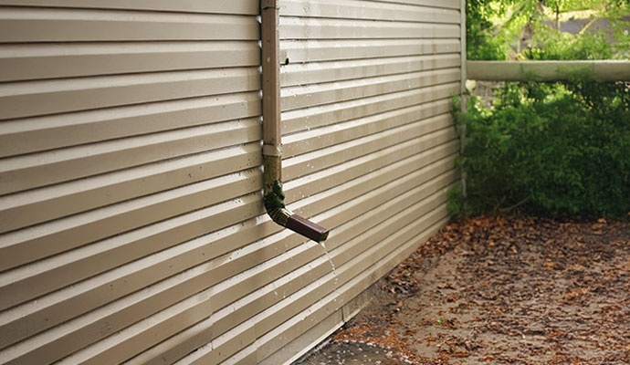 A downspout dripping water onto the ground