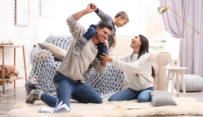 Happy family playing on a rug in a clean and dry home