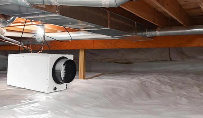 A dehumidification system installed in a crawl space to reduce moisture