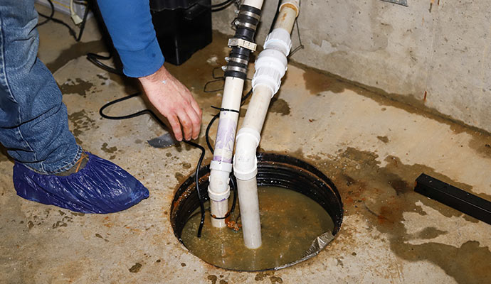 Professional worker repairing sump pump