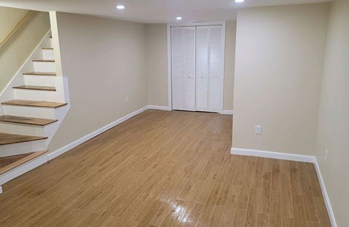 Professionally finished basement with clean flooring and bright lighting